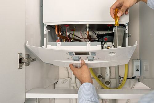 Heating technician repairing a residential boiler in Redondo Beach