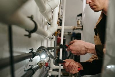 Technician inspecting commercial plumbing pipes in Redondo Beach