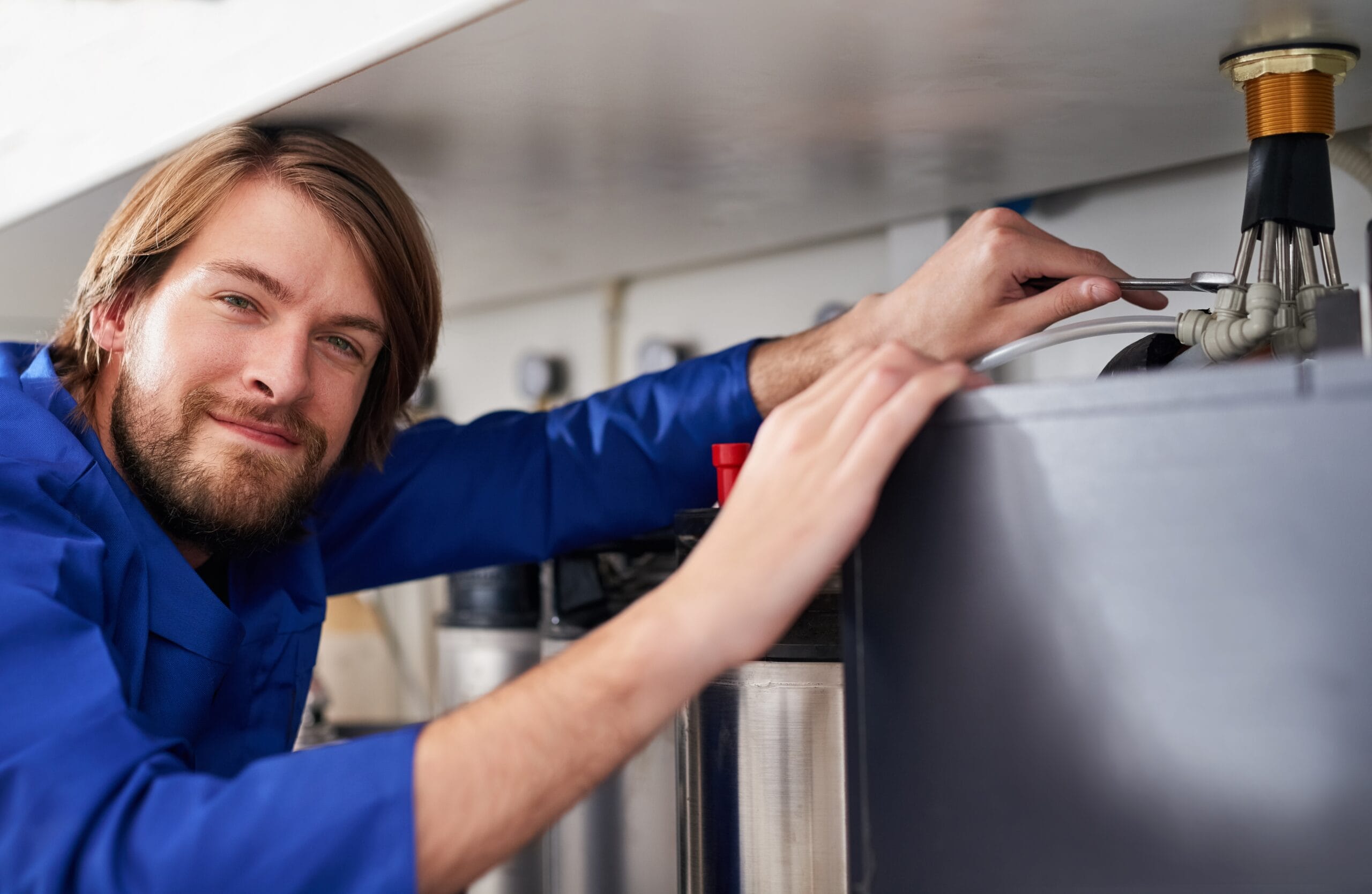 Technician servicing a residential water heater tank in Redondo Beach